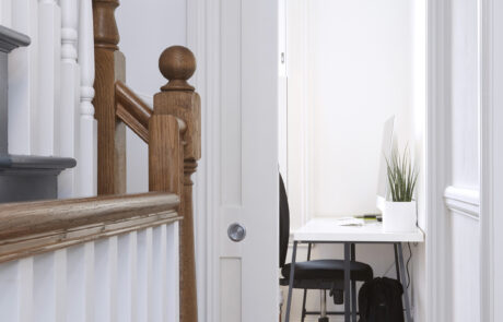 Interior stairs and pocket door with black and white color scheme, featuring natural wood accents for a modern, elegant look.