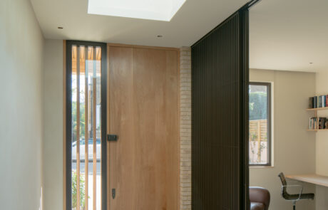 Entrance hall with skylight, natural color scheme, warm wood tones, and modern design.